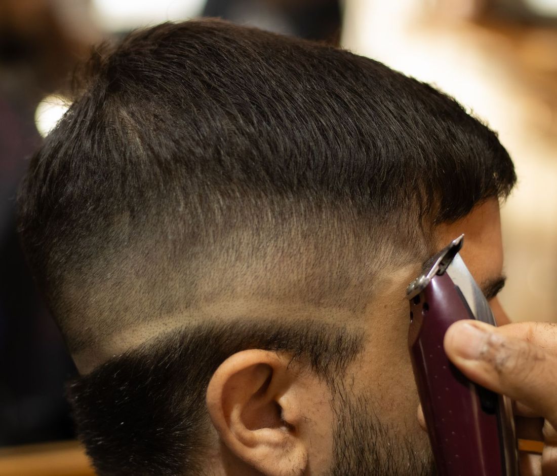 Barber perfecting a skin fade with clippers